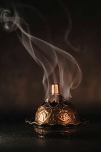 A beautifully detailed incense burner with ornate patterns and rising smoke, creating a calming atmosphere.